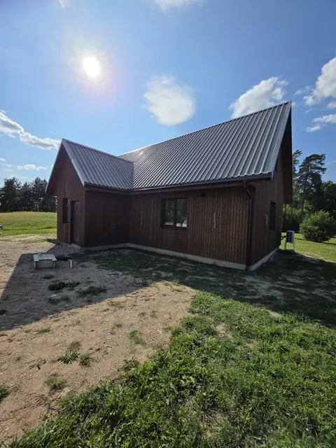 Užbaigta rudo namo išorė iš kiemo pusės